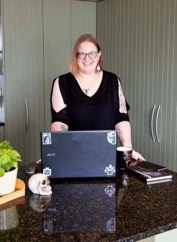 On Point Marketing Owner, Louise McKay standing behind laptop